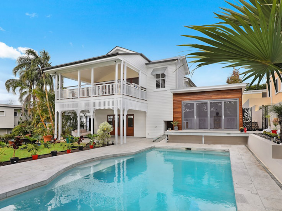 Modern luxury home exterior with pool, professionally photographed for a real estate listing